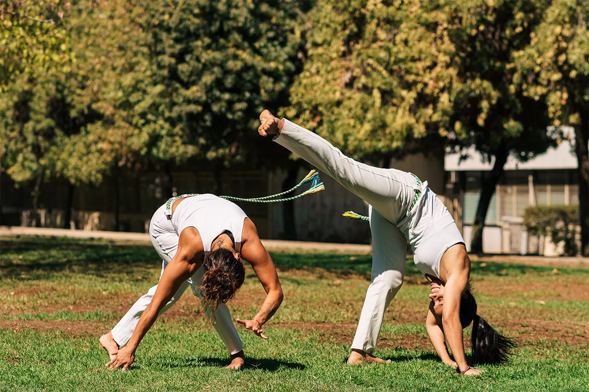 mujeres practicando capoeira al aire libre
