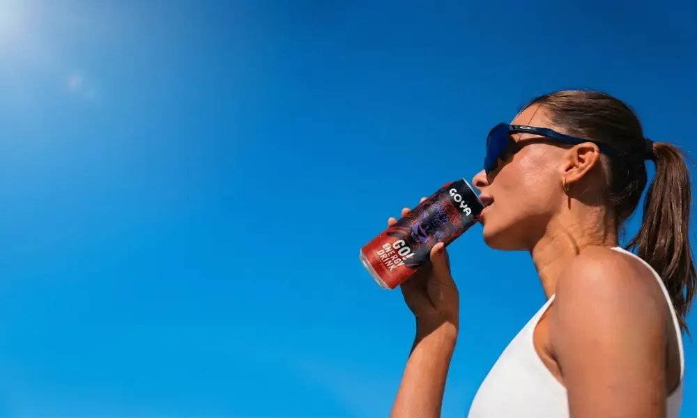 Chica bebiendo GO Energy Drink un día soleado