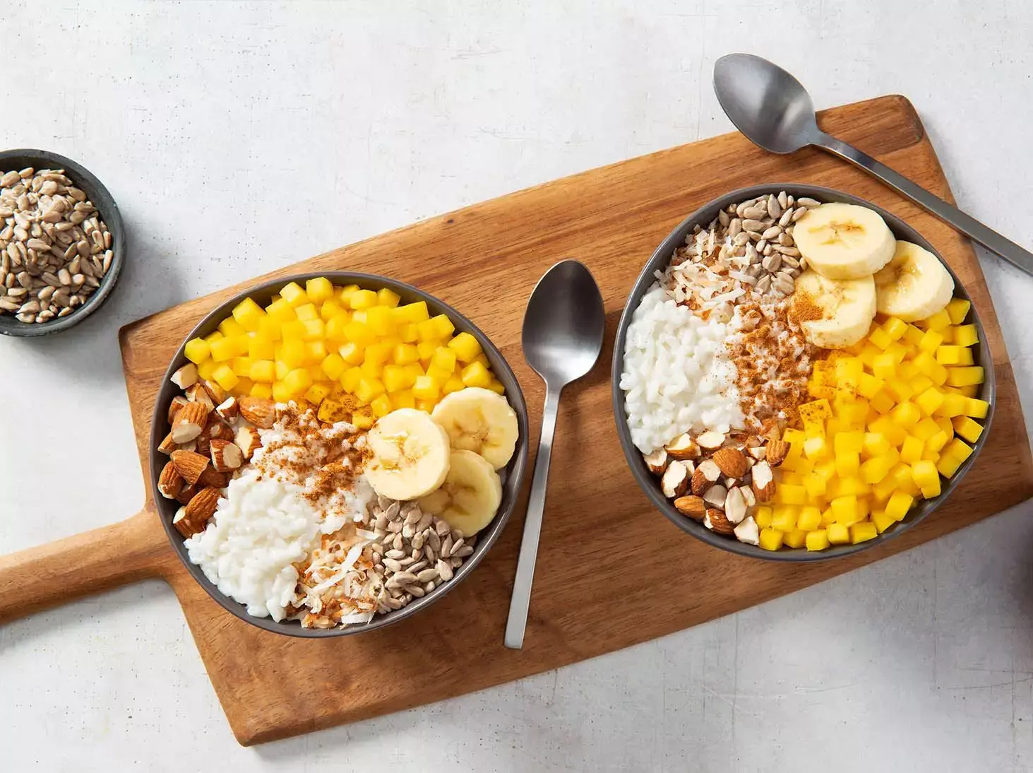 Desayunos de arroz con leche de coco, almendras, mango y plátano