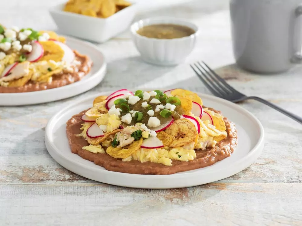 Chilaquiles de pollo con chips de plátano, refritos y salsa verde